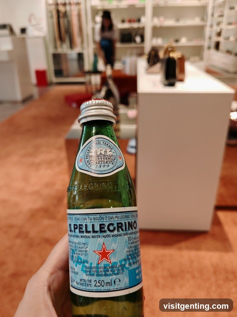 Hand holding S.Pellegrino bottle inside a store