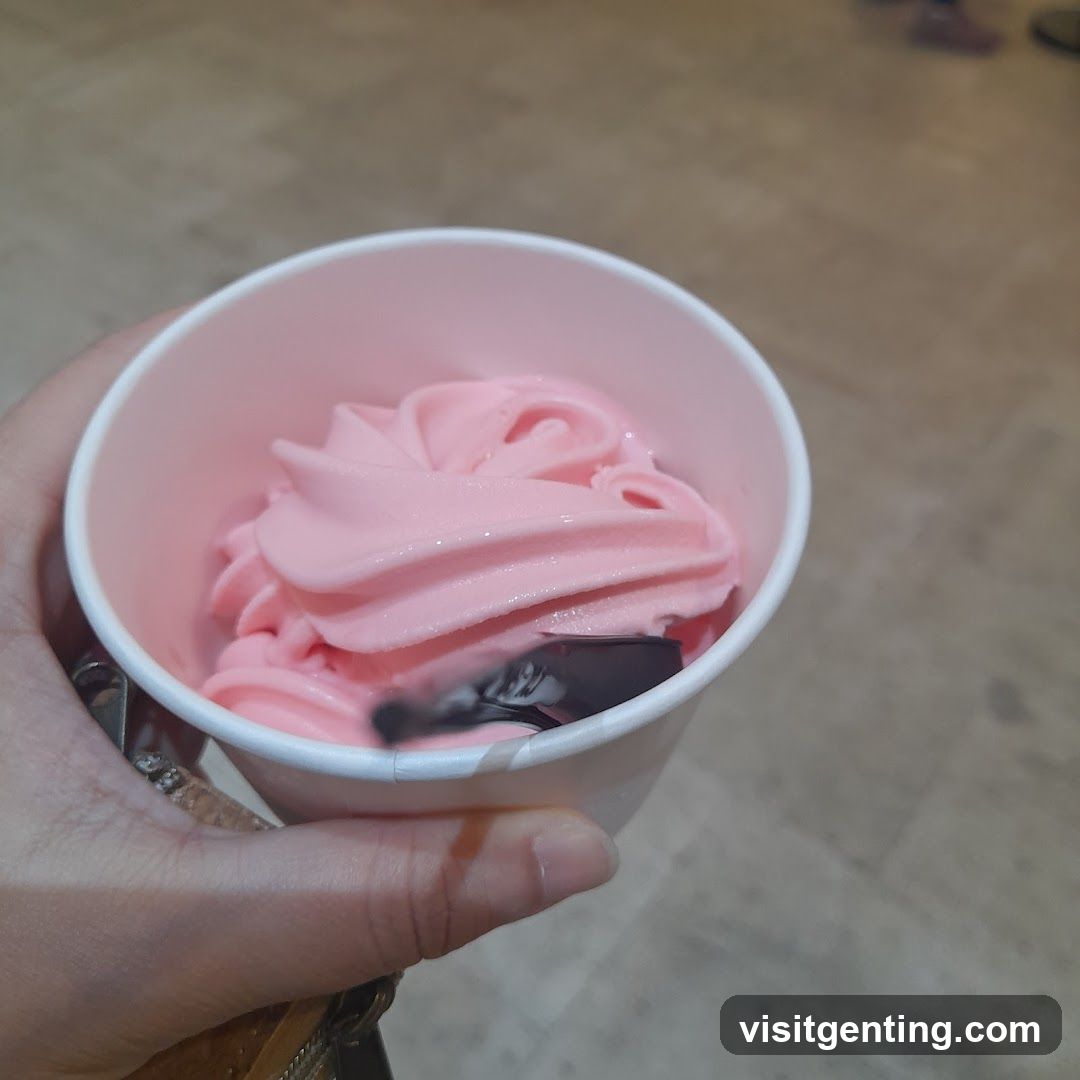 Hand holding pink soft serve in cup