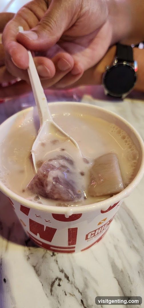Hand holding spoon in dessert cup