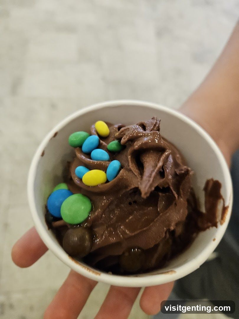 Hand holding chocolate ice cream with candies