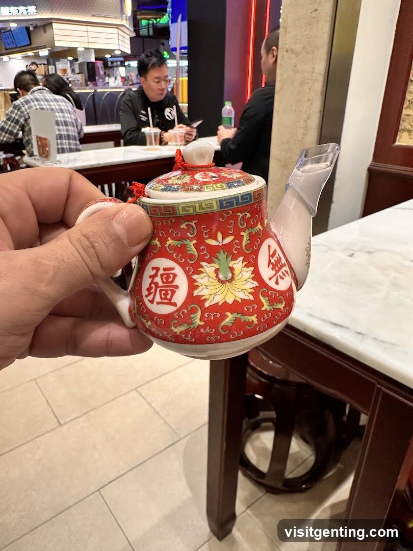 Hand holding decorative teapot in restaurant interior