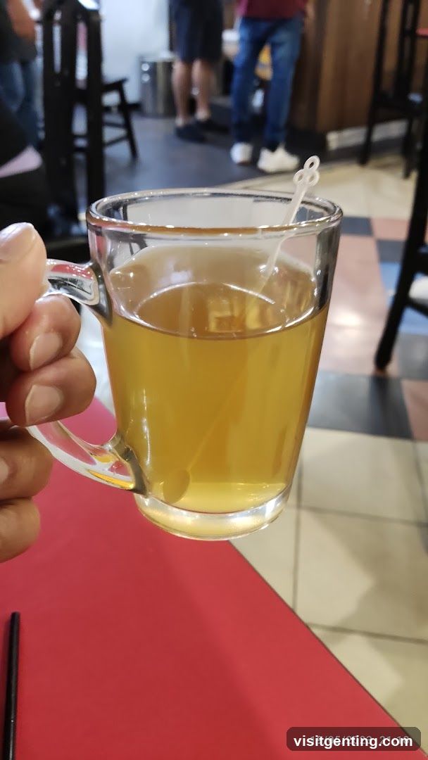 Hand holding a glass mug of tea