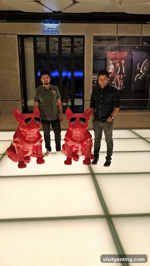 Two men posing with red dog statues in front of Adidas store