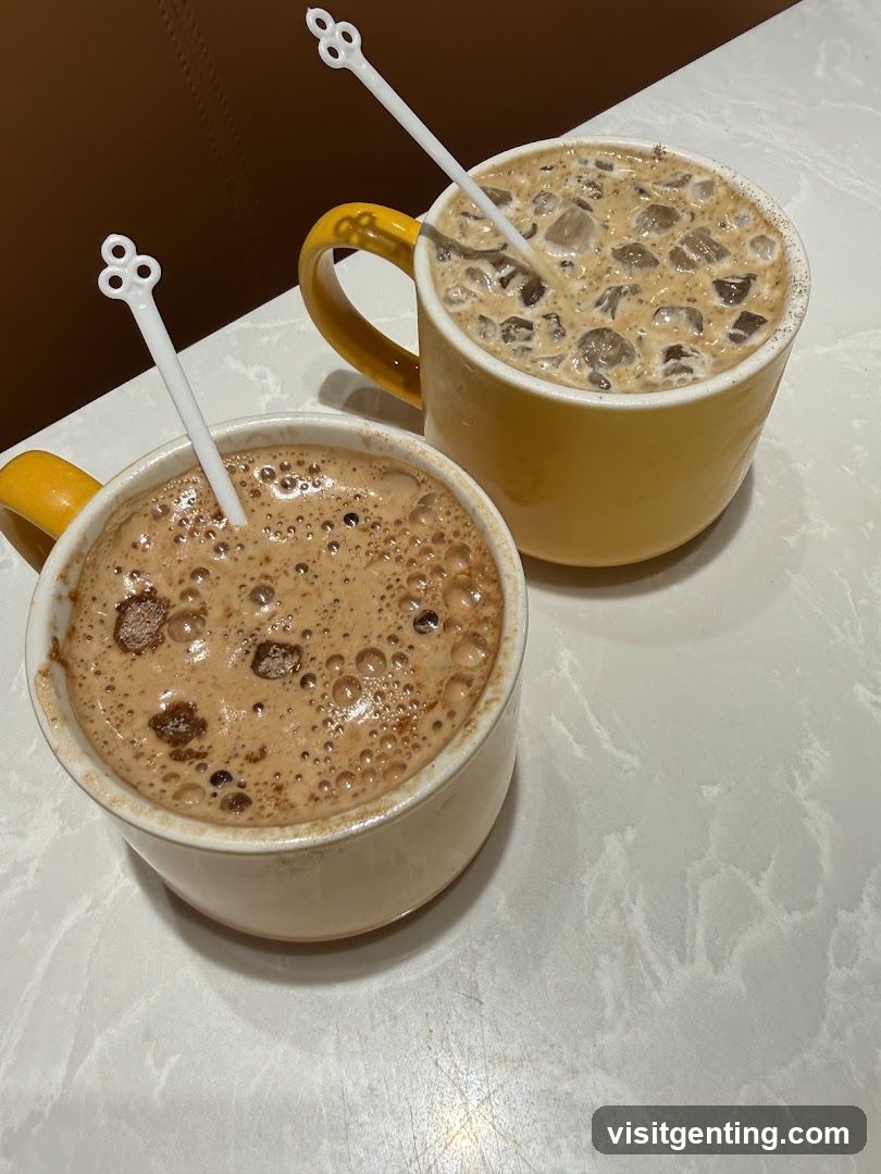 Two beverages in yellow mugs on a white marble table