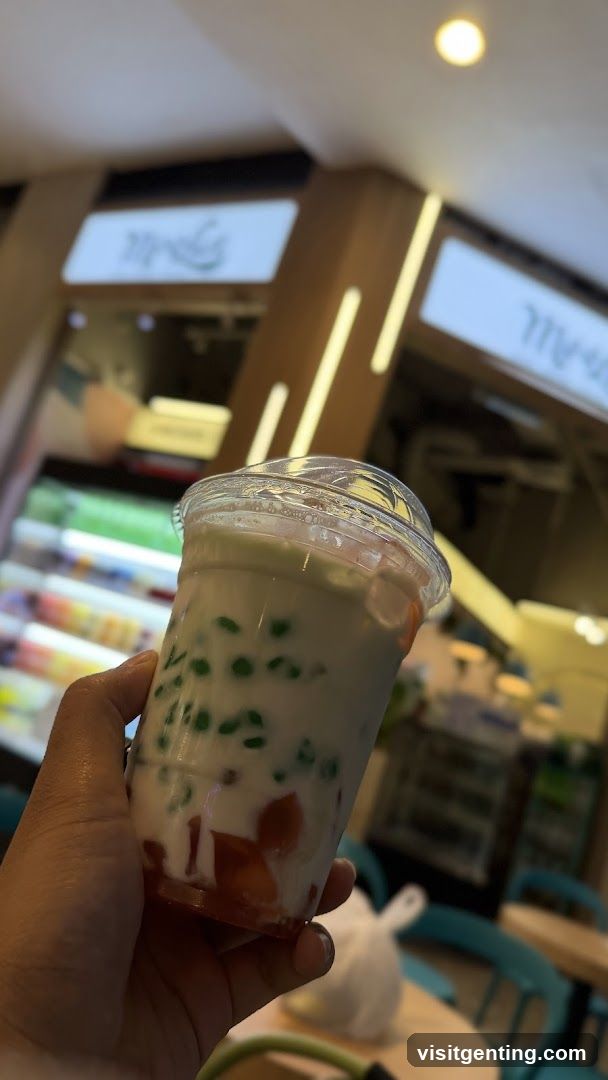Hand holding a drink in an indoor setting
