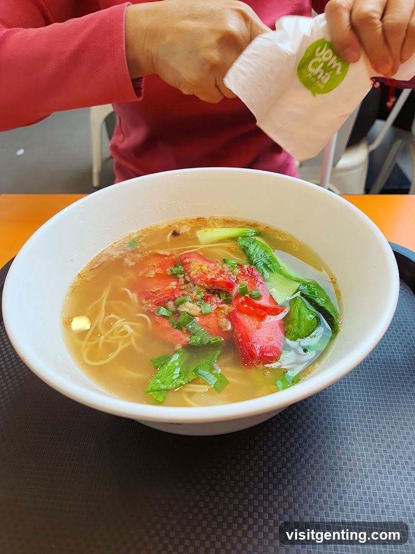 Person at dining table with noodle soup