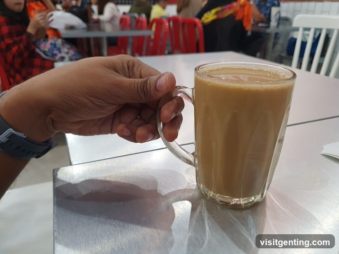 Hand holding a glass mug of tea in a café