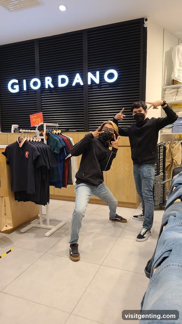 Two individuals posing inside Giordano store