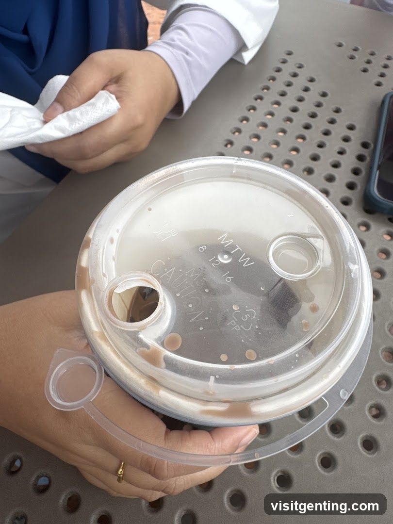 Hand holding drink lid