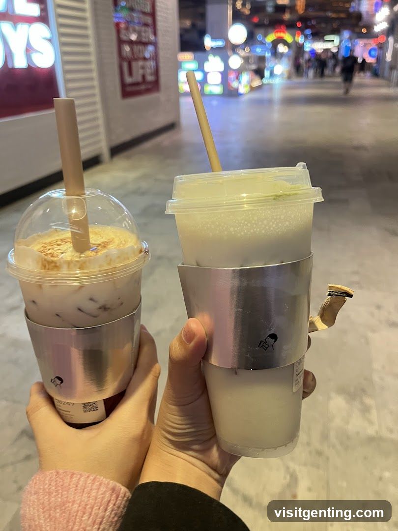 Two beverages held in hands at night street