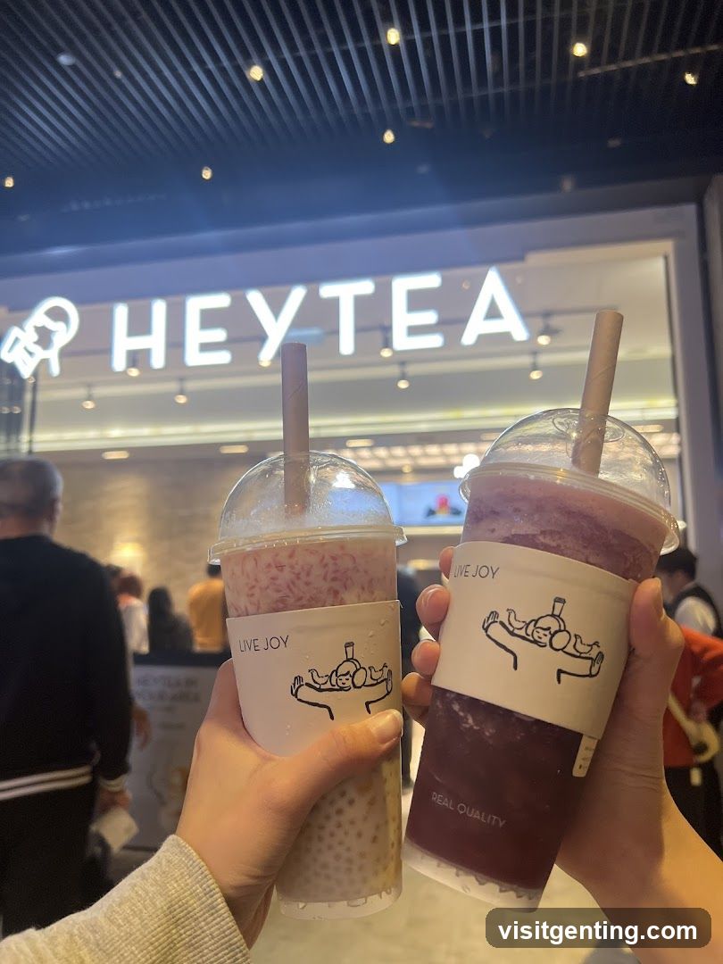 Two hands holding HeyTea drinks in front of a store