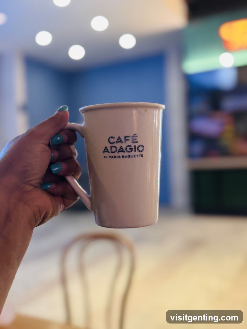 Hand holding Café Adagio mug