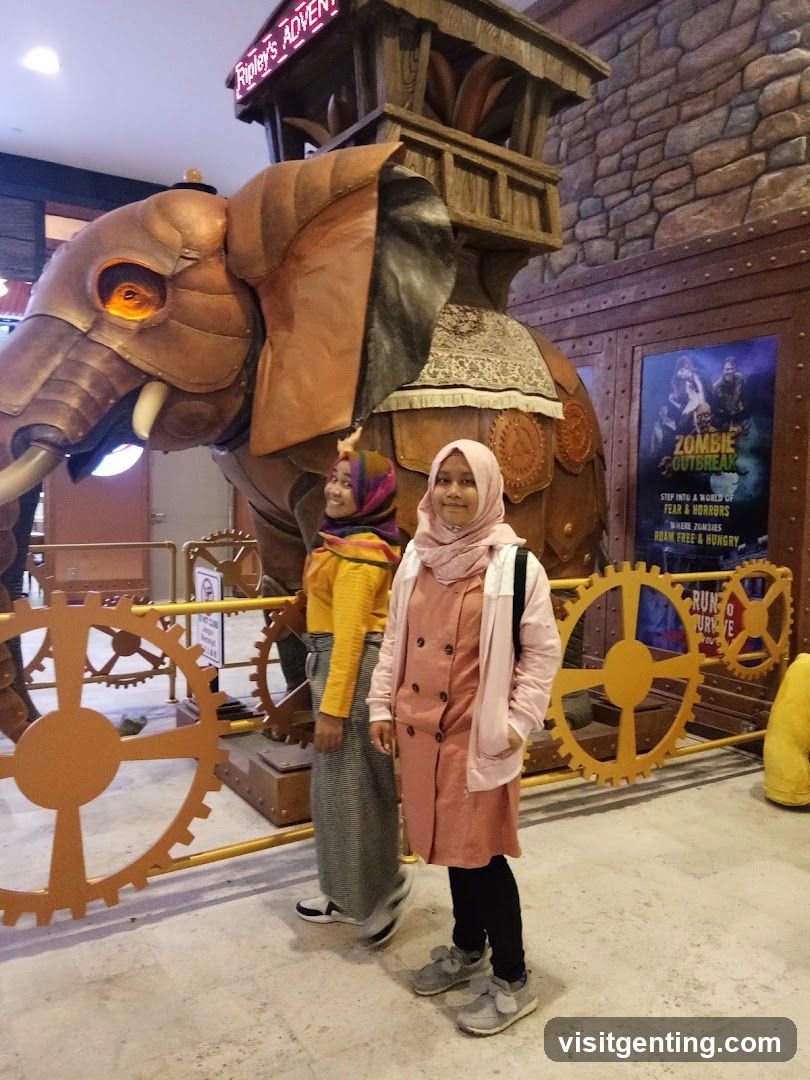 Two individuals posing in front of a mechanical elephant display
