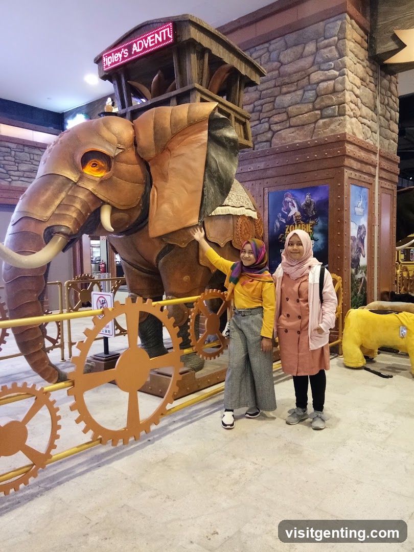 Two individuals posing with a mechanical elephant display