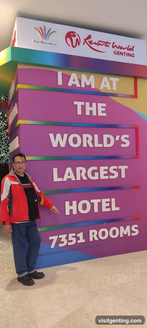 Man standing beside hotel sign