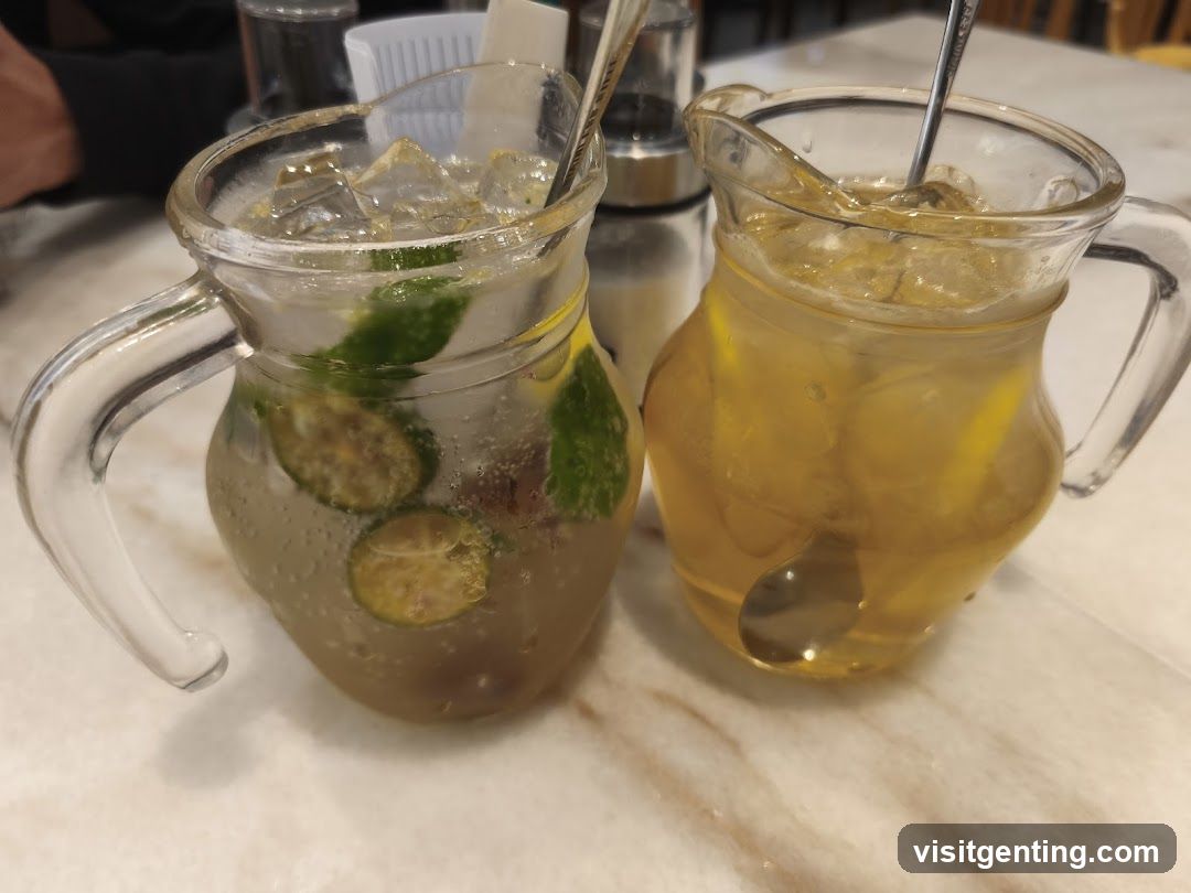 Two iced beverages in glass pitchers on a table