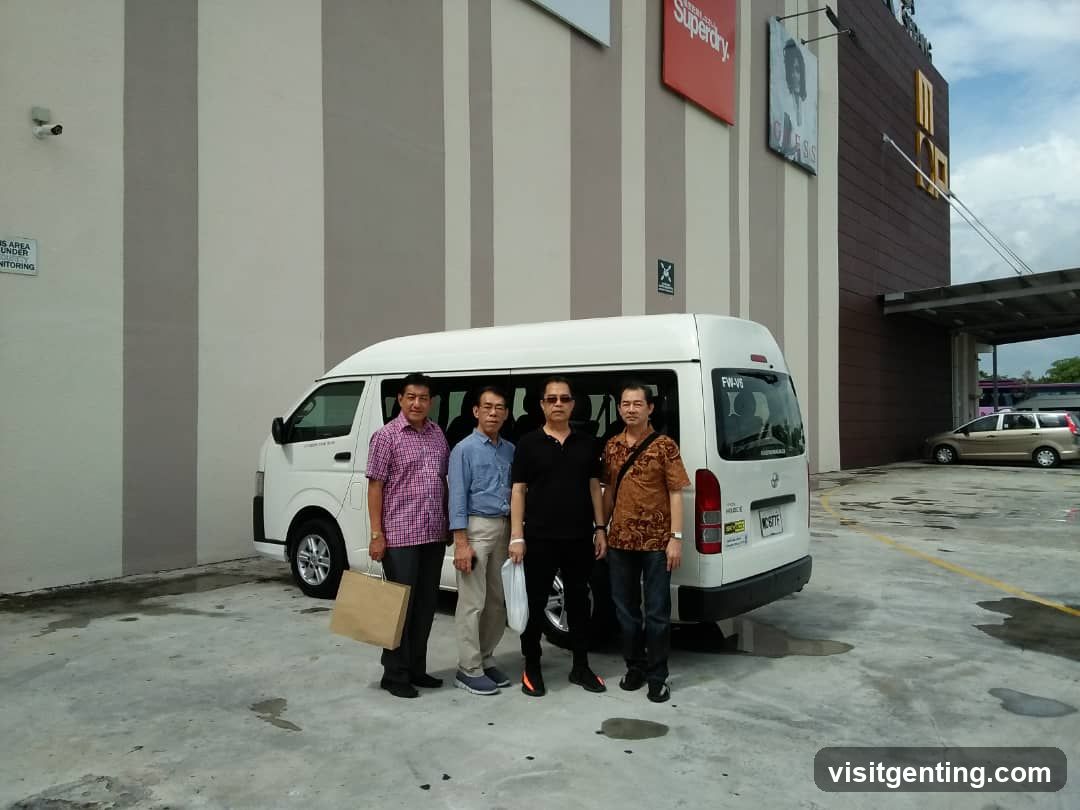Group of men posing in front of a van near a commercial building