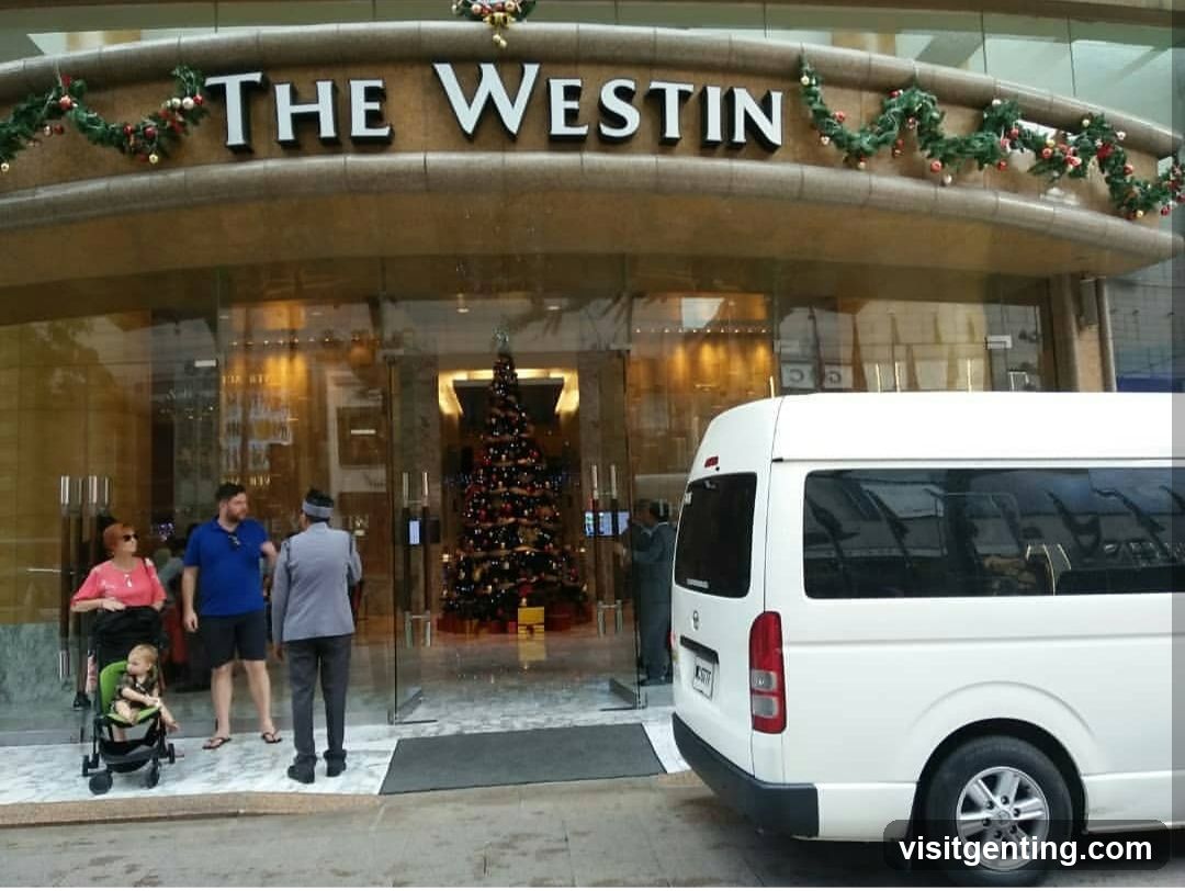 Exterior view of The Westin hotel entrance with festive Christmas decorations including garlands on the facade above the glass doors. A large decorated Christmas tree is visible inside through the glass. Several people are outside near the entrance, including a family with a stroller. A white van is parked to the right.
