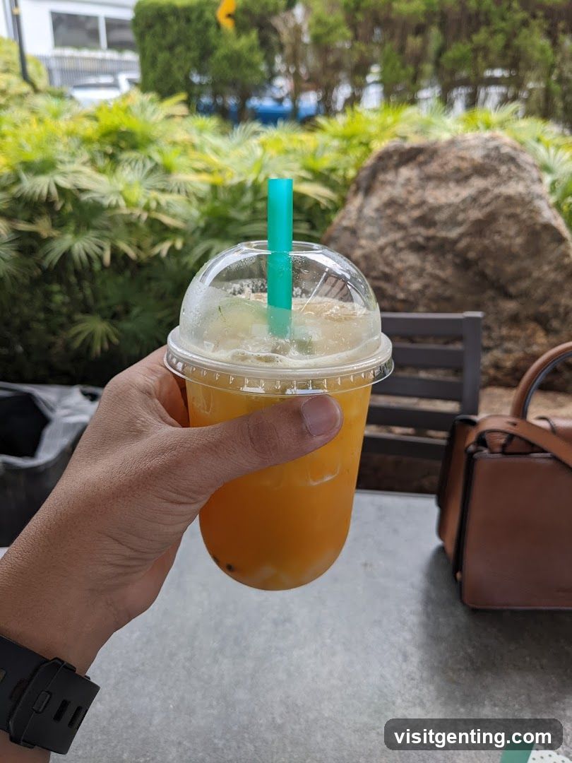 Hand holding iced drink outdoors