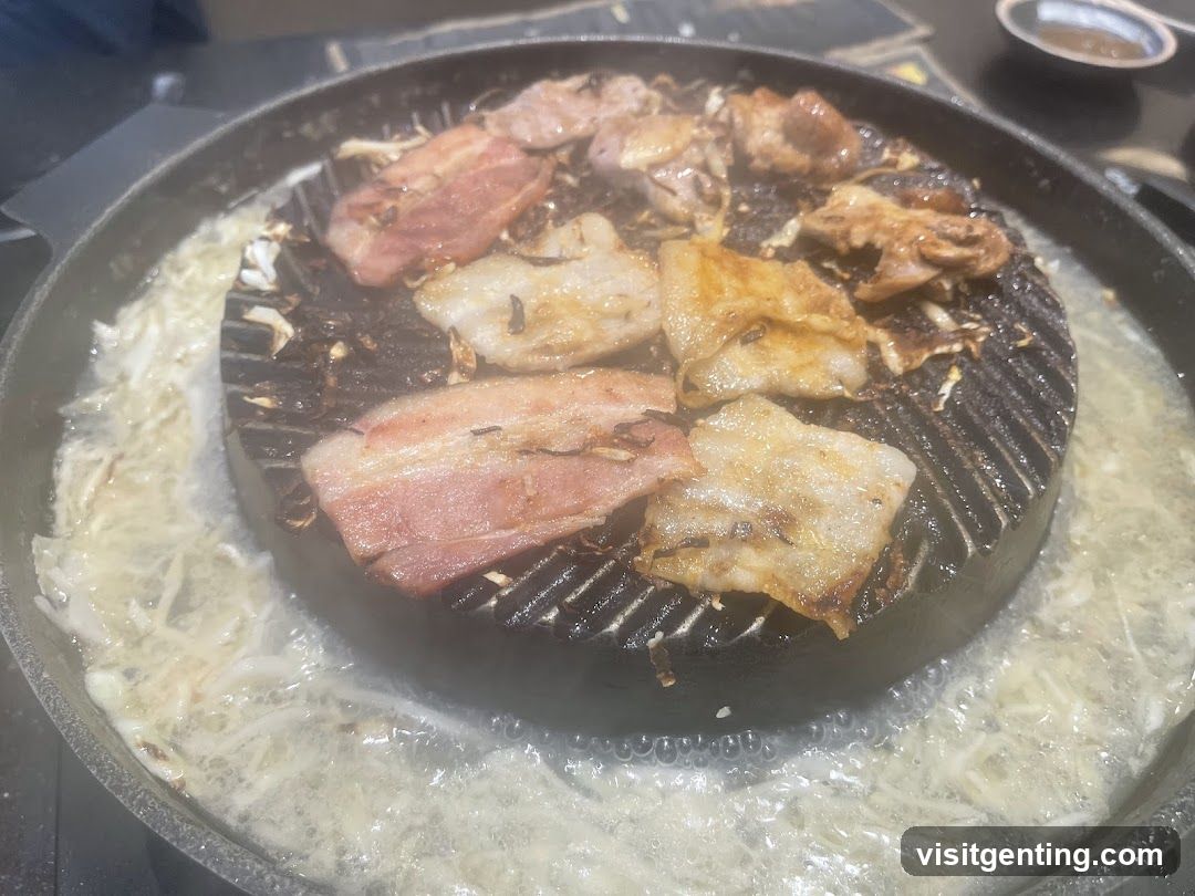 Grilled meat on a hot plate with bubbling broth
