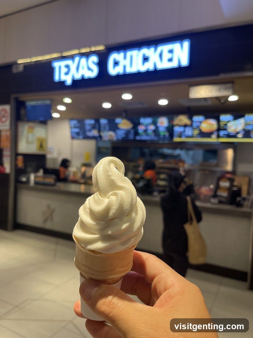 Hand holding soft serve ice cream in front of Texas Chicken restaurant