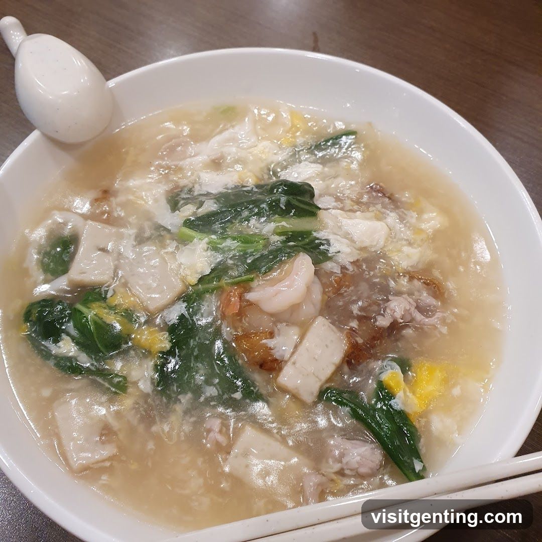 Soup in bowl with spoon and chopsticks