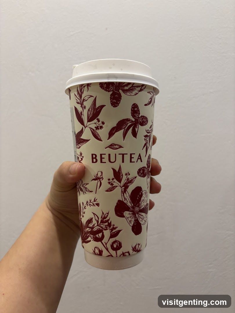 Hand holding Beutea branded cup