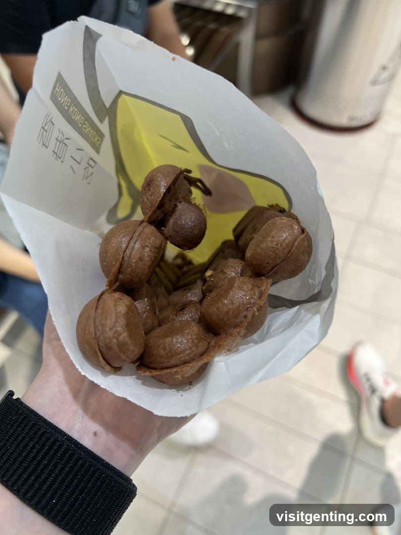 Hand holding chocolate-flavored bubble waffles