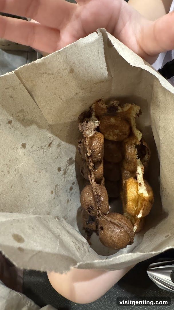 Hand holding waffle in paper bag