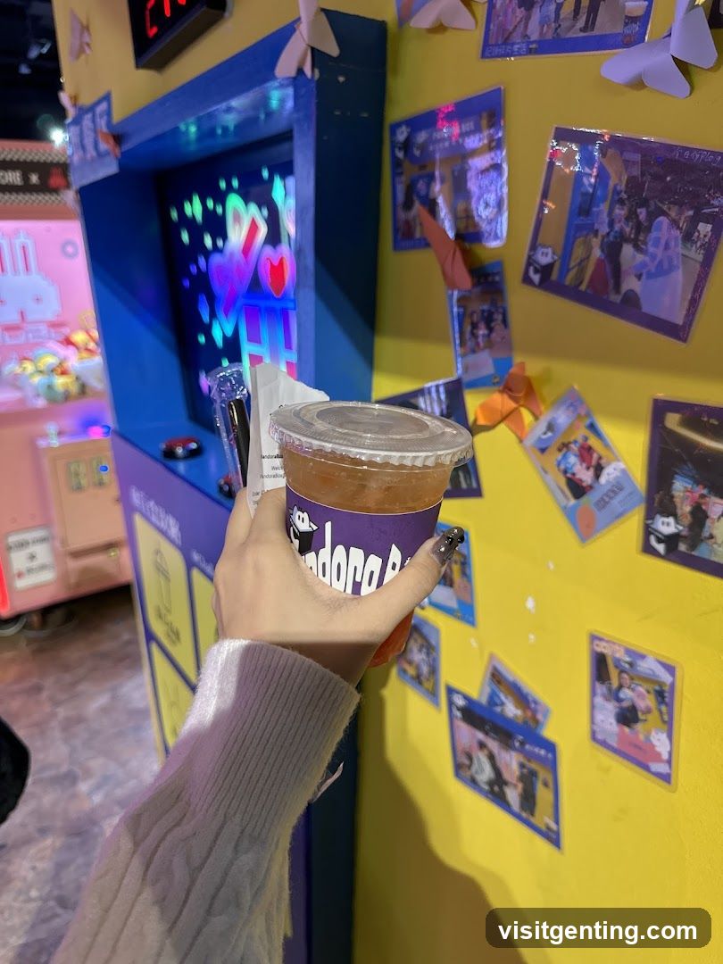 Hand holding drink in arcade setting