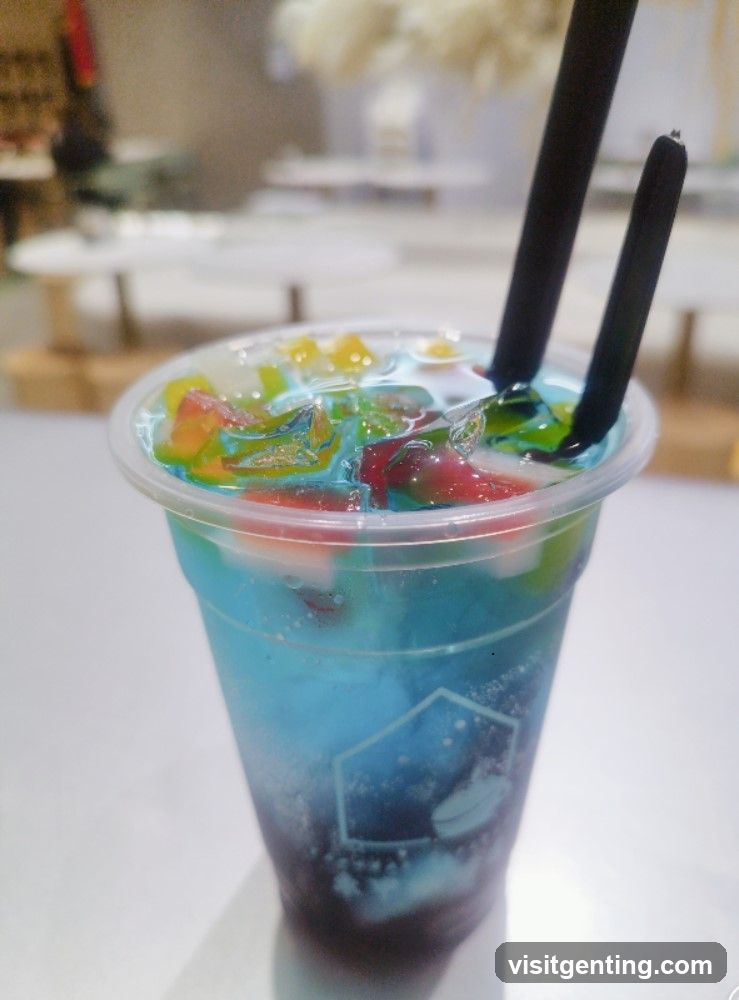 Colorful beverage in a plastic cup with two straws