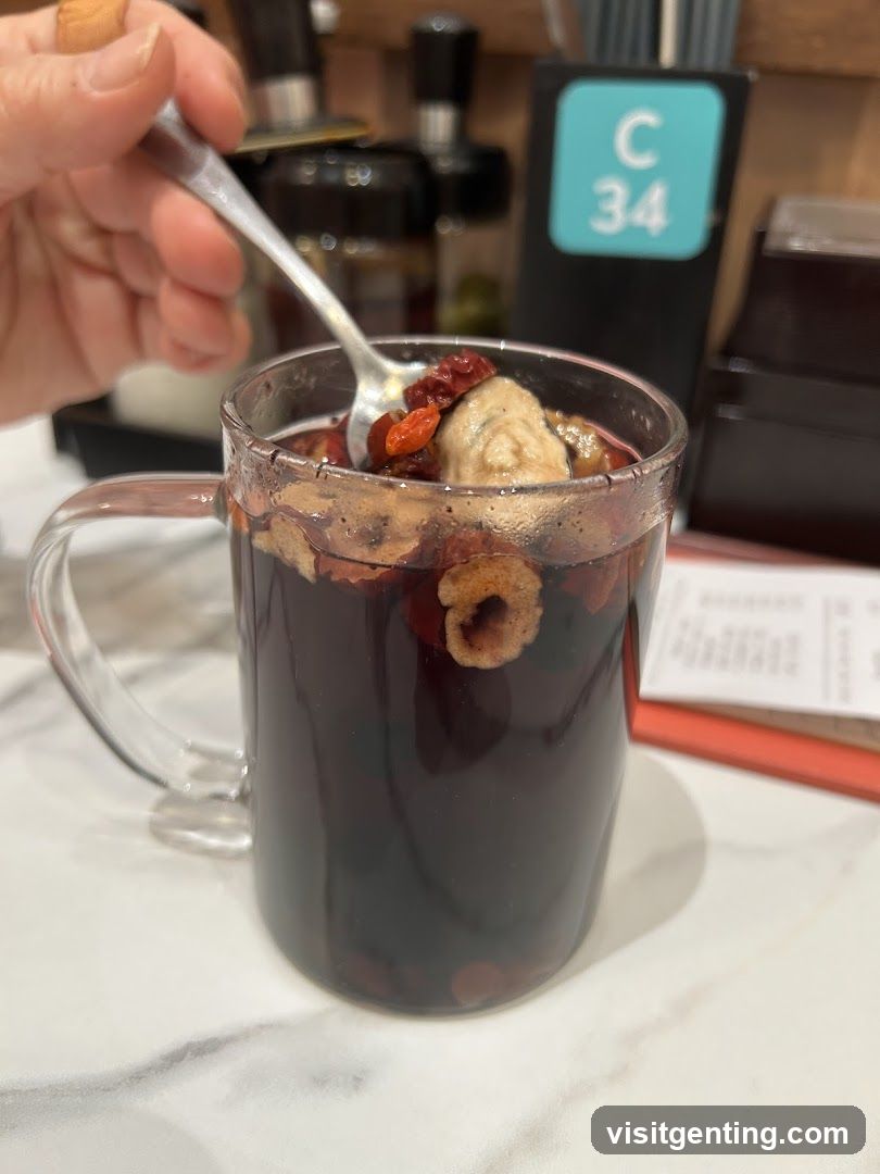 Hand holding spoon over herbal drink