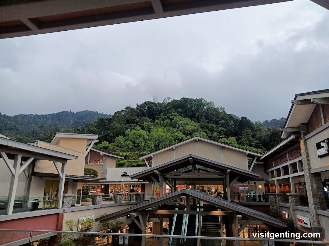 Outdoor shopping complex with lush green hills in the background