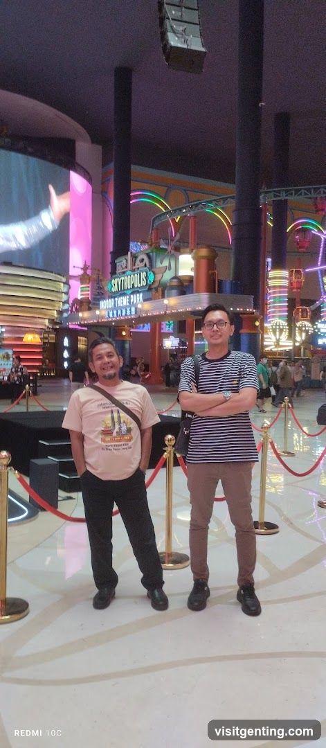 Two men posing in an indoor theme park entrance area
