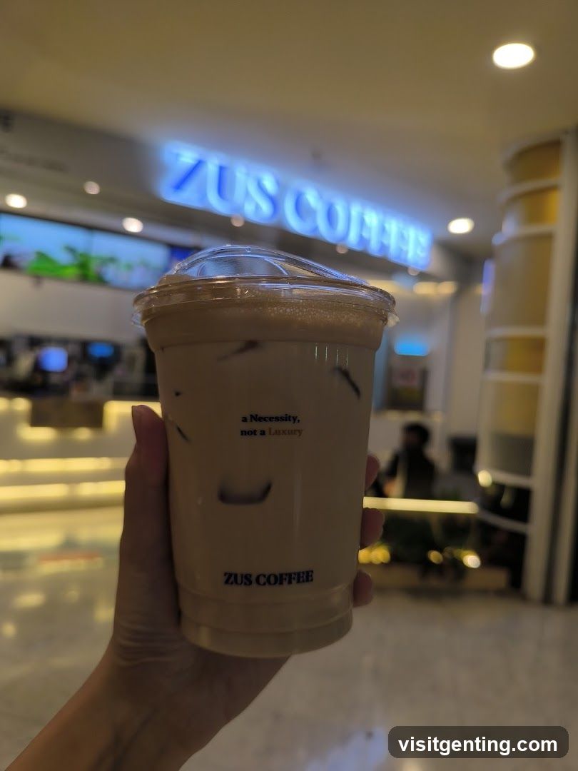 Hand holding a ZUS COFFEE drink