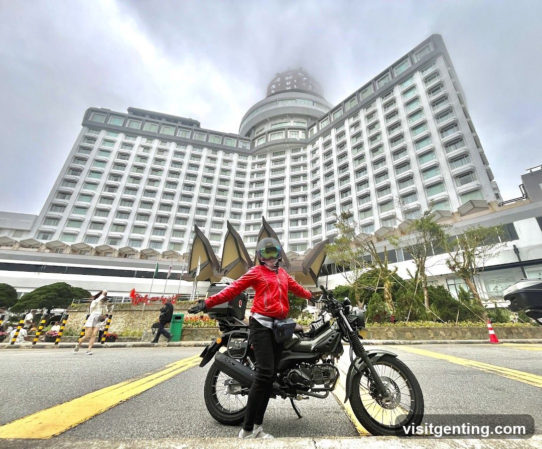 Motorcyclist in front of large building