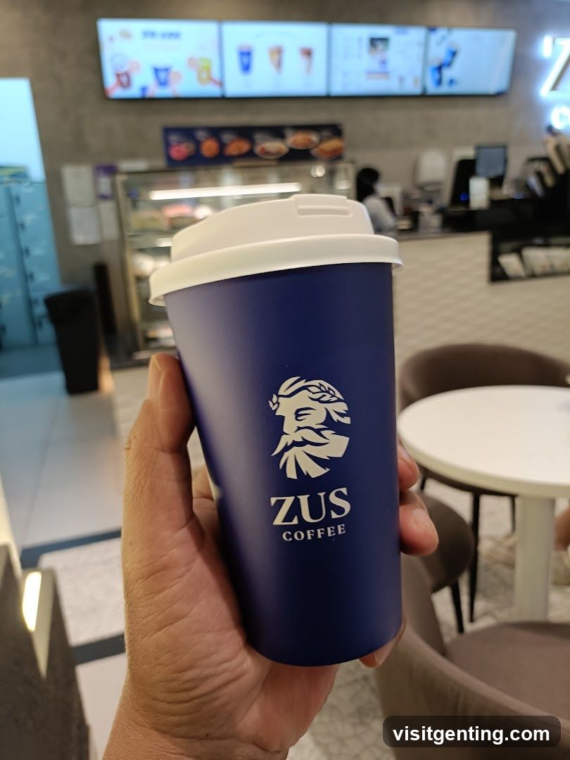 Hand holding a coffee cup from ZUS COFFEE