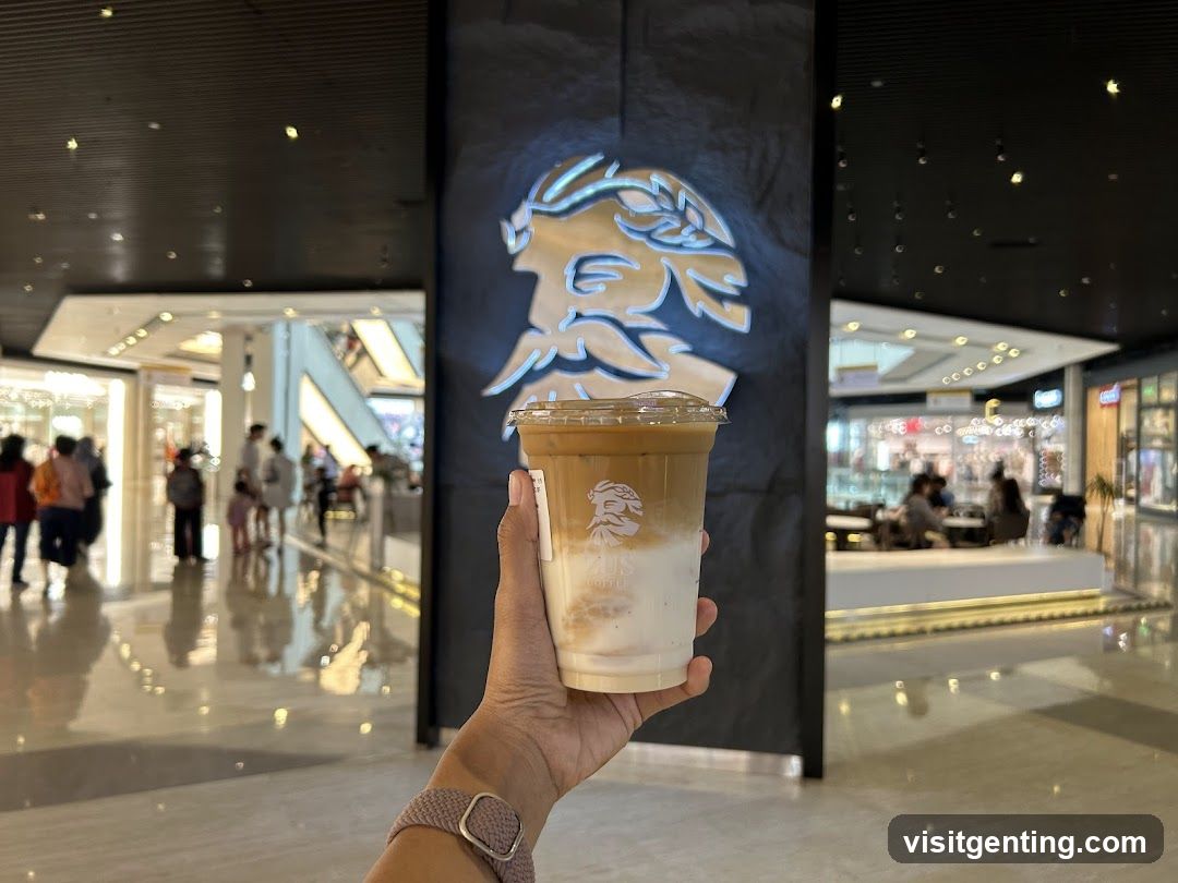 Hand holding iced coffee in shopping mall