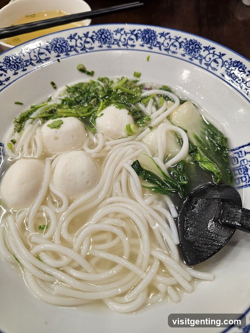 Bowl of noodles with fish balls and greens