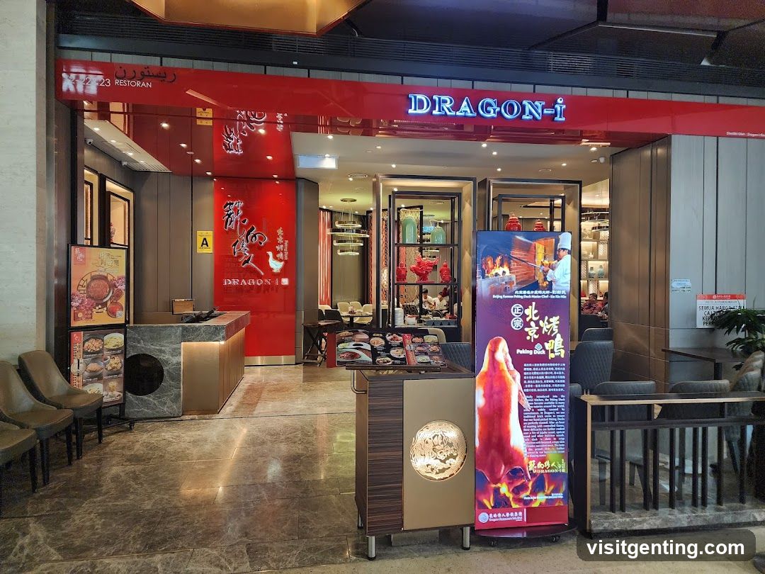 Modern storefront with red and gold accents, featuring illuminated "DRAGON-i" sign in blue letters above the entrance. The facade includes a reception counter with a circular cutout, glass display cases inside, and interior lighting. A large promotional poster advertising Beijing Roast Duck stands beside the entrance on a stand.
