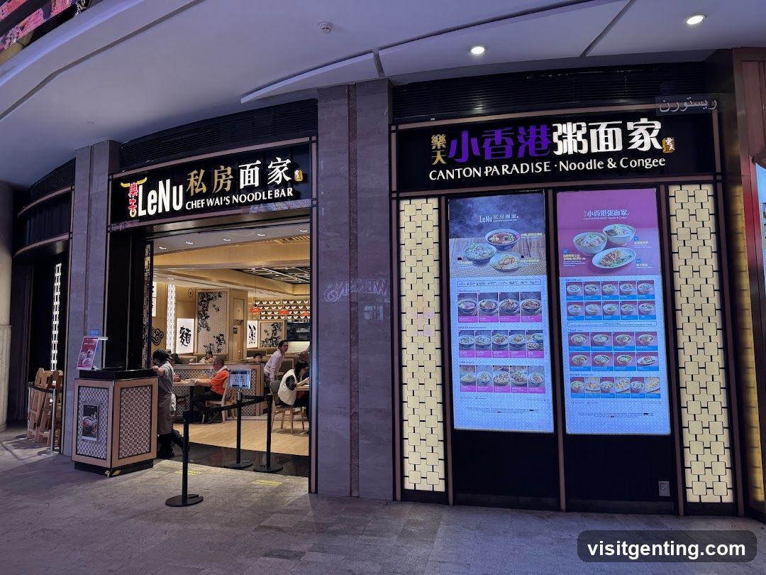 Two adjacent noodle bars with illuminated signs above entrances. Left: LeNu Chef Wai's Noodle Bar; right: Canton Paradise · Noodle & Congee. Both have glass doors, interior lighting, and customers seated inside. A staff member is at the counter on the left. The right side has decorative panels with embedded LED screens displaying menu items.